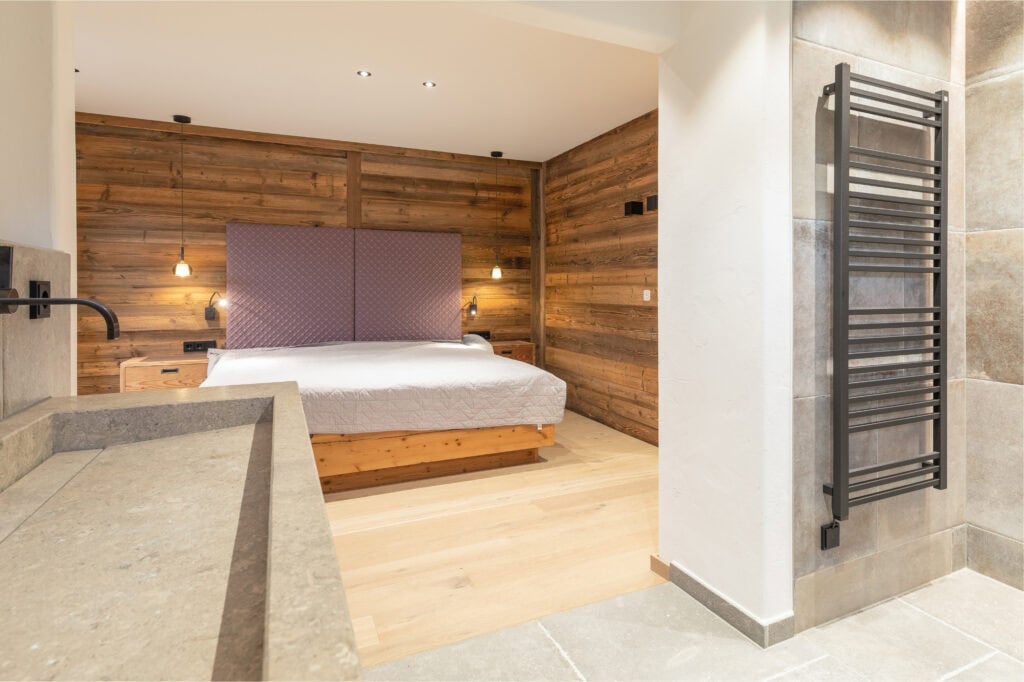 Schlafzimmer und Bad sind hier integriert. Vom Steinwaschbecken blickt der Betrachter ins Schlafzimmer.