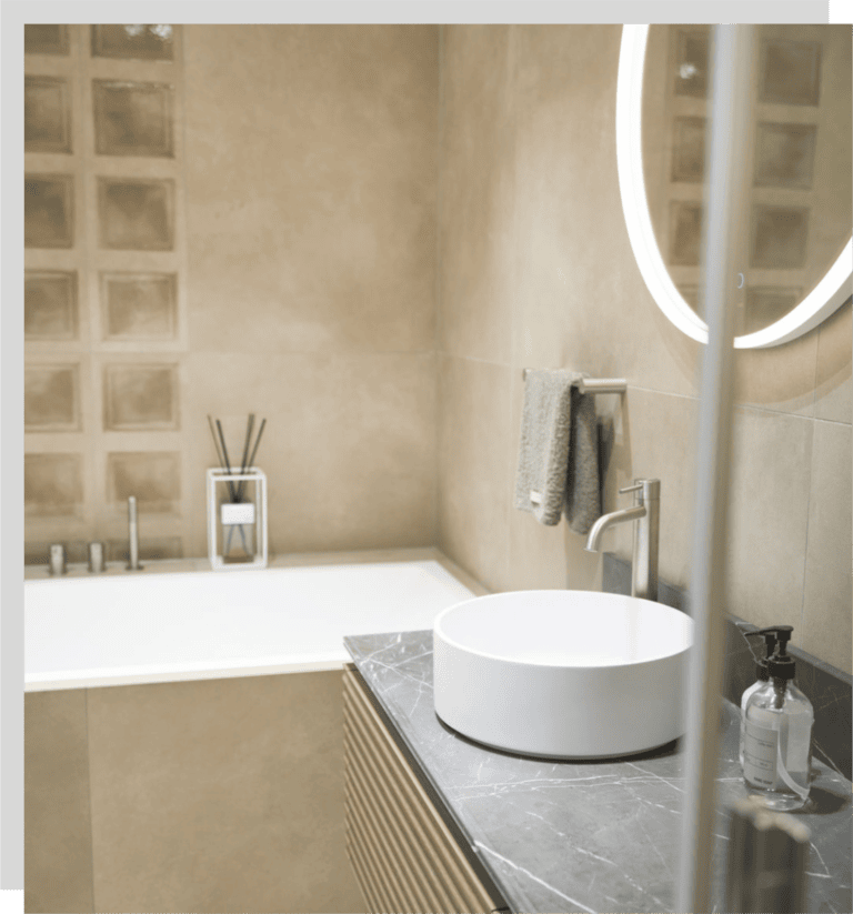 Beiges Bad mit Spachteloptik an der Wand mit aufgesetztem, weißem Keramikwaschbecken.