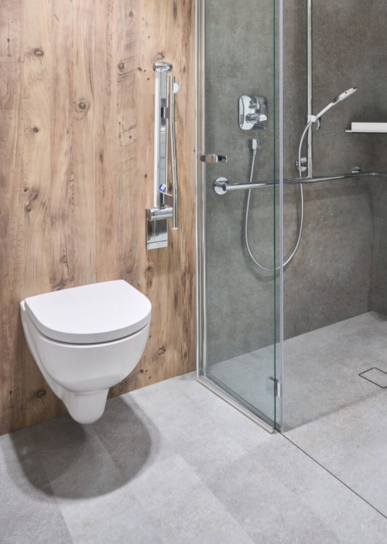 Barrierefreies Bad mit Toilette (inklusive Rehling zum Festhalten), sowie eine ebenerdige Dusche.