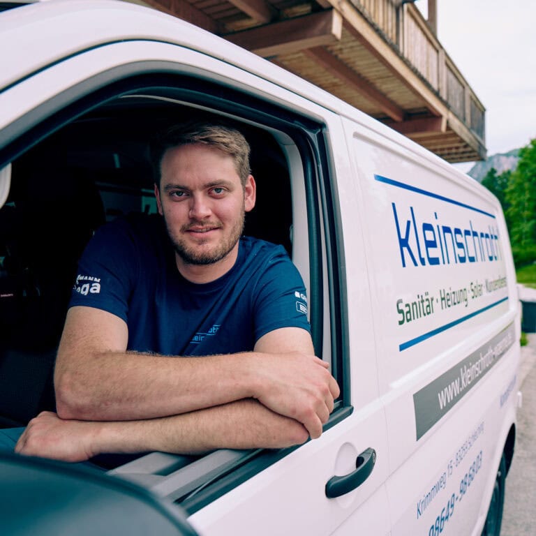 Ein Mitarbeiter des SHK Betriebs Kleinschroth lächelt aus dem Auto.
