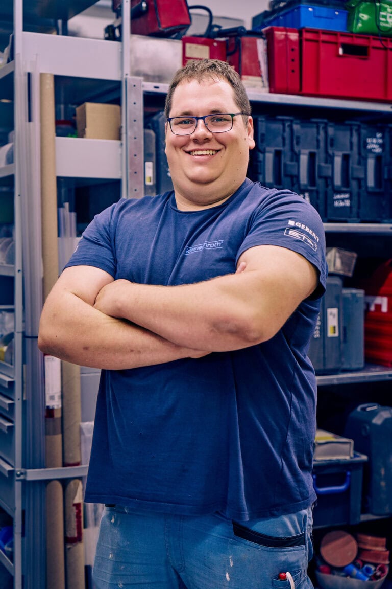 Sebastian Lindlacher steht im Lager und lächelt.