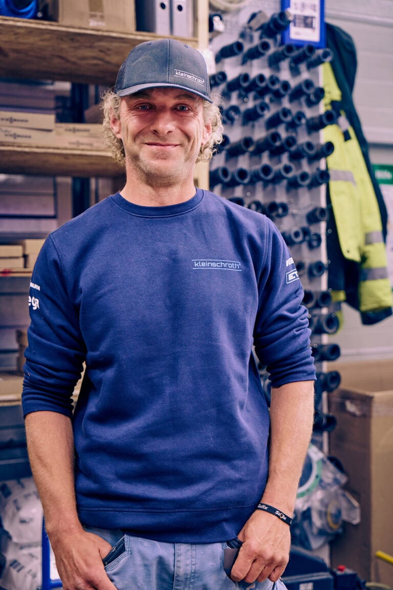 Mitarbeiter Simon Presker steht im Lagerraum der Firma.