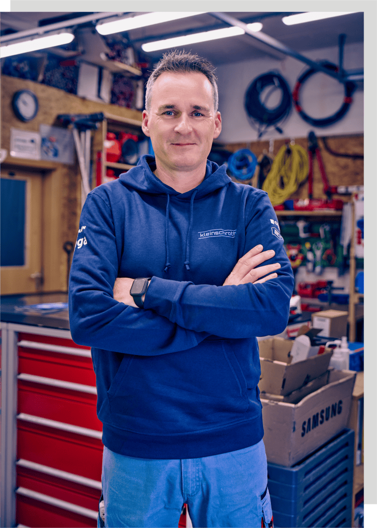 Firmeninhaber Timo Kleinschroth ist hier lächelnd im blauen Hoodie abgebildet.